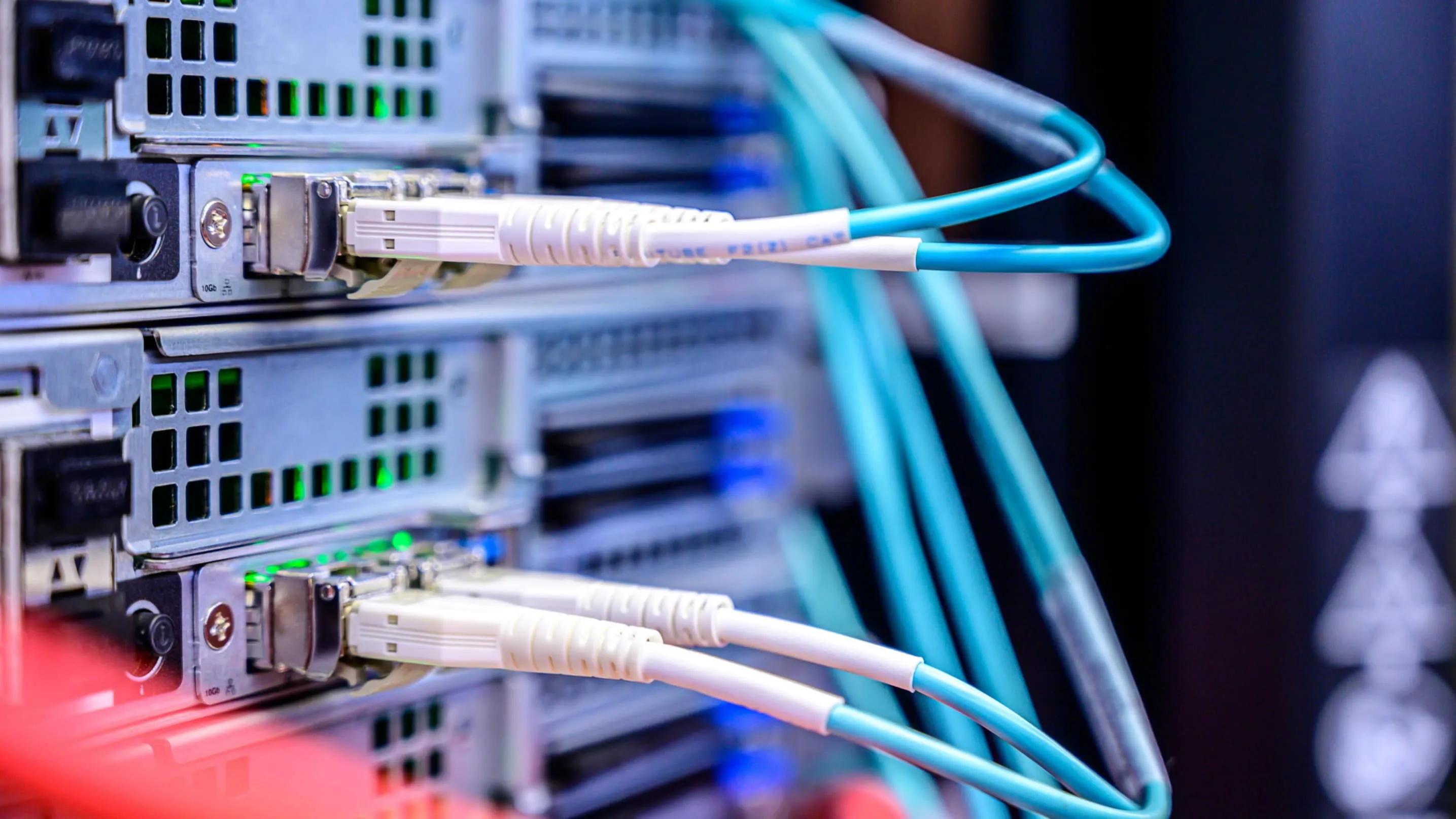 Fibre optic patch leads plugged into the 10Gb ports of rack-mounted network equipment